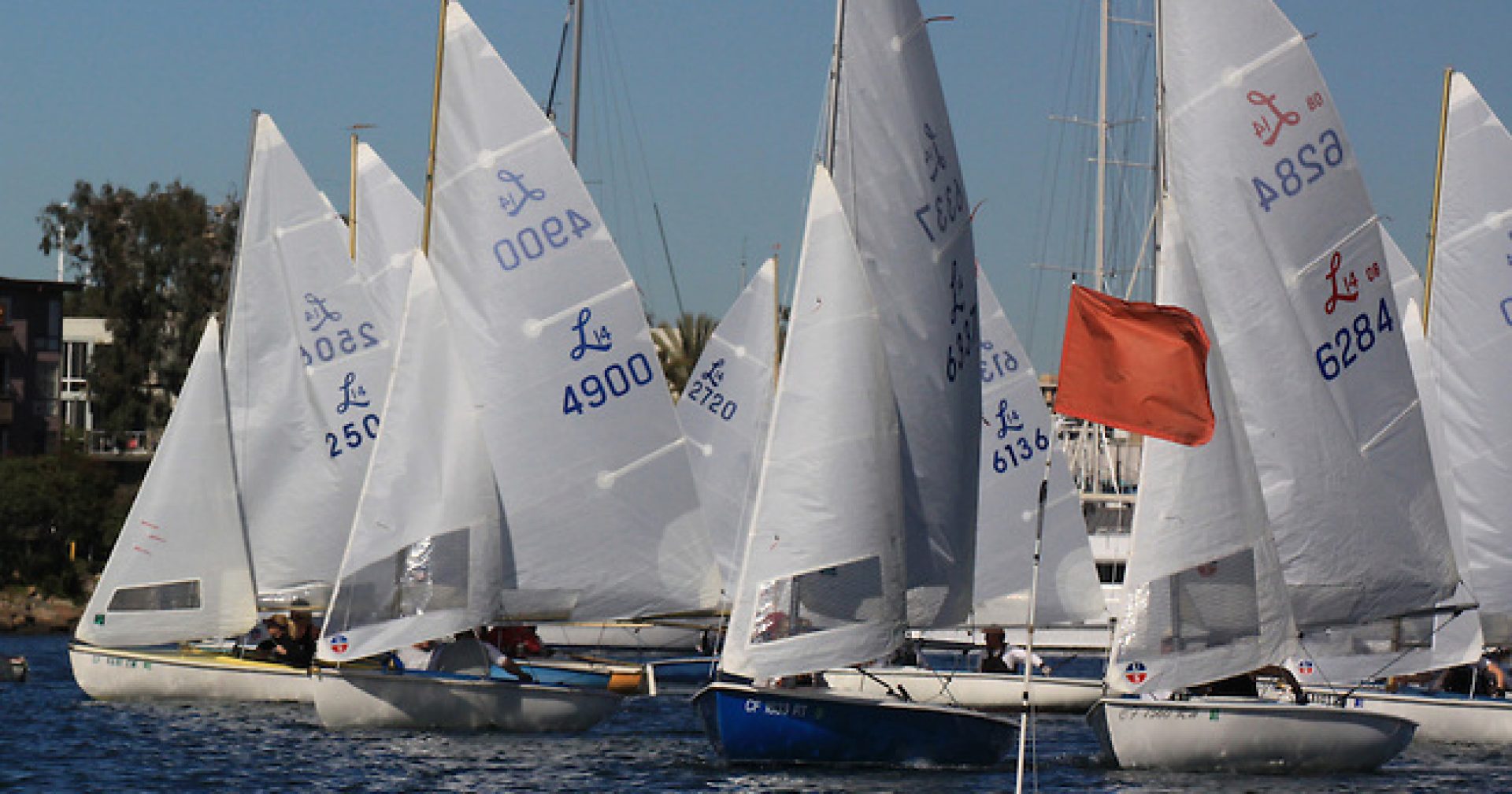 Several sailboats on the start line of a race